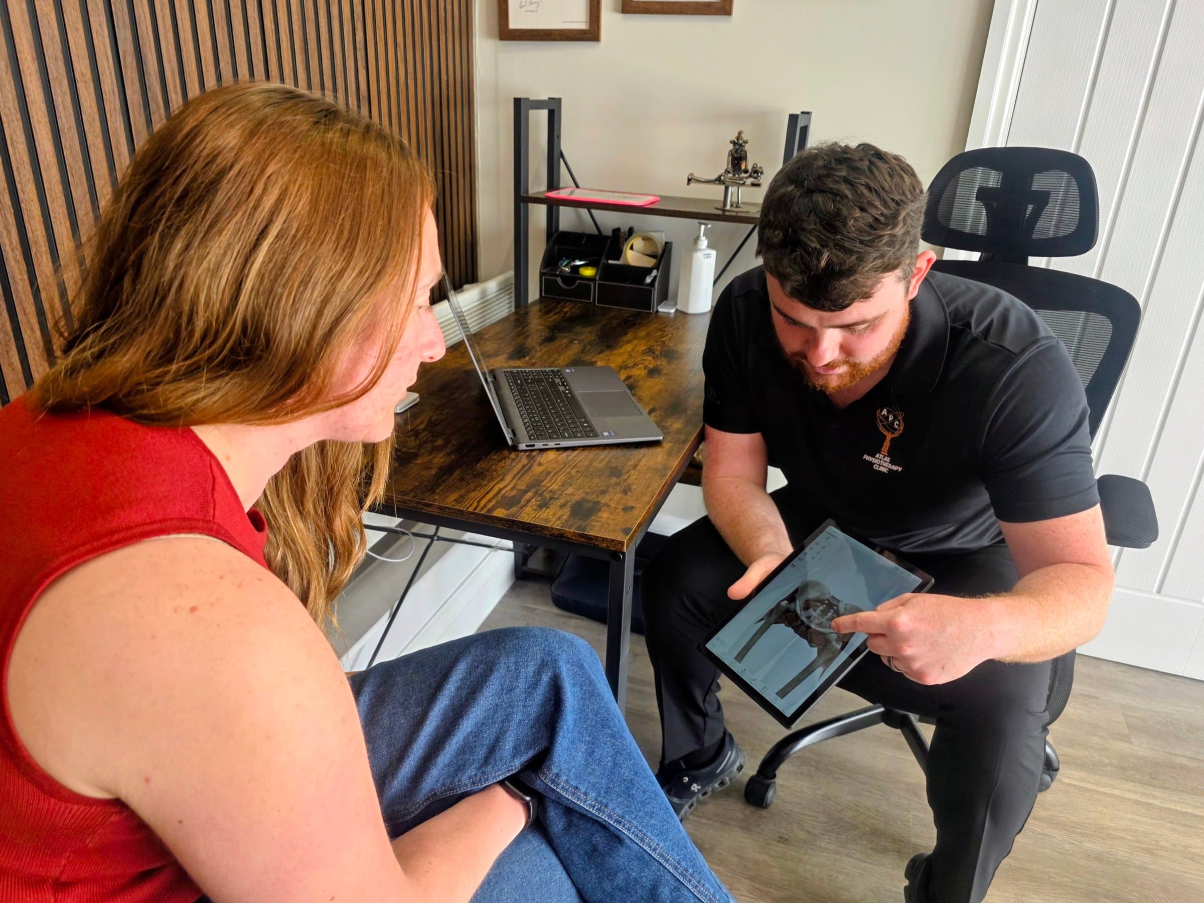 Connor explaining anatomy on a tablet during a patient consultation