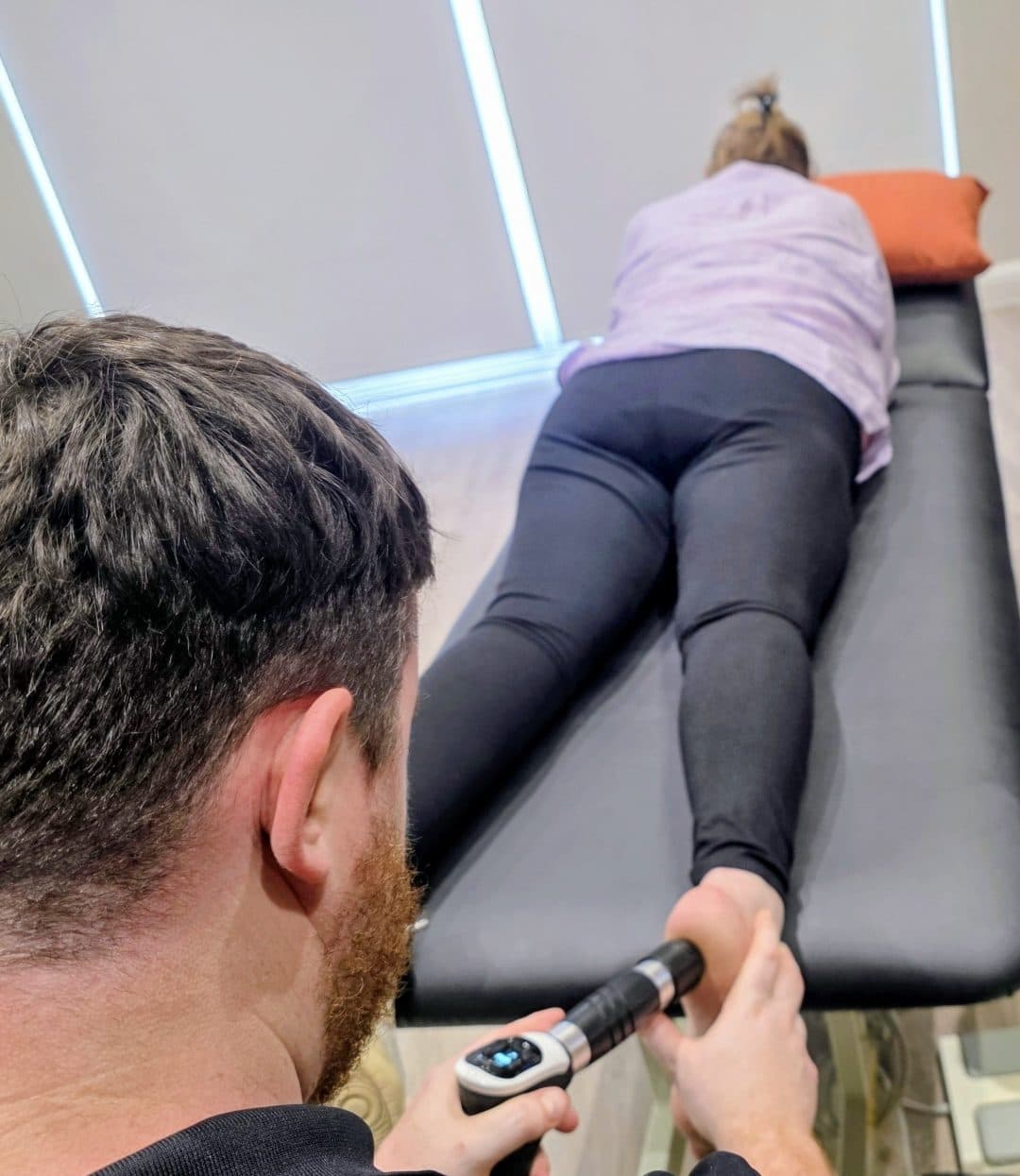 Connor delivering shockwave therapy to a patient&rsquo;s foot at the clinic